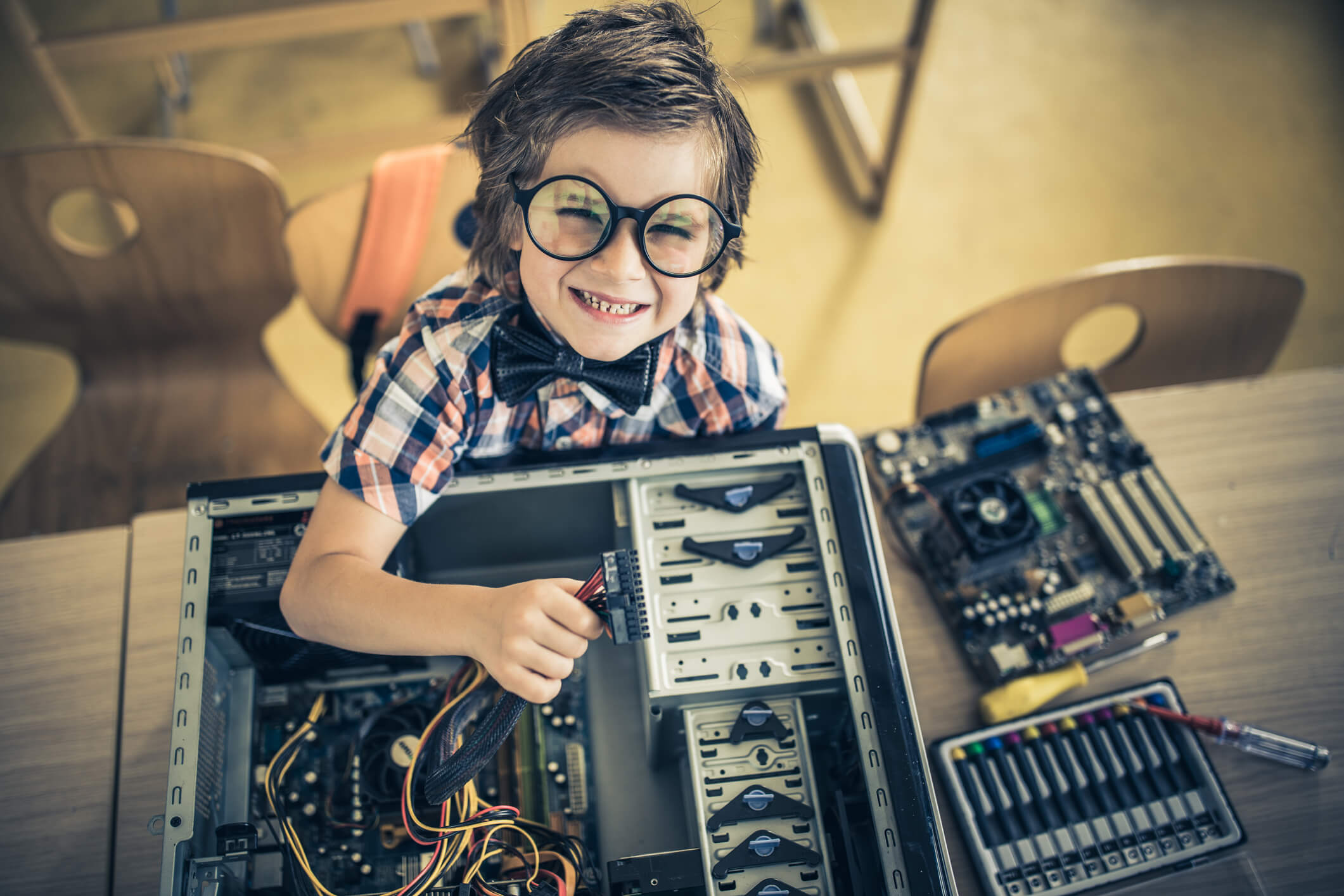 Happy child fixing computer hardware.