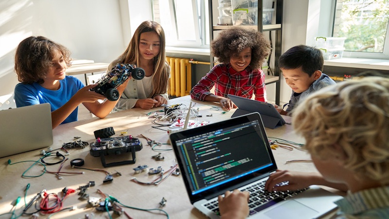 Group of children working on robotics and coding projects