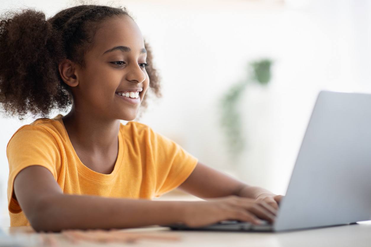 Smiling girl sitting at a laptop