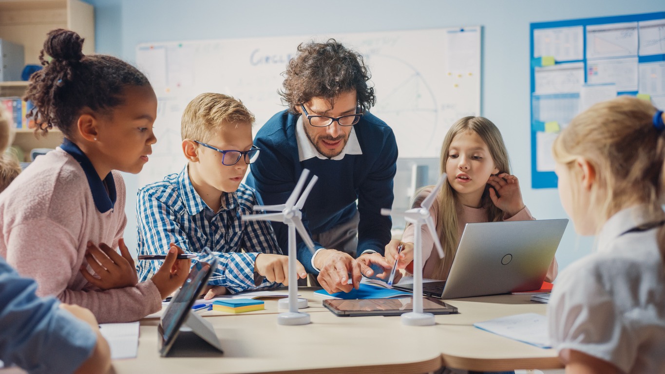 Teacher guiding children in a classroom STEM activity