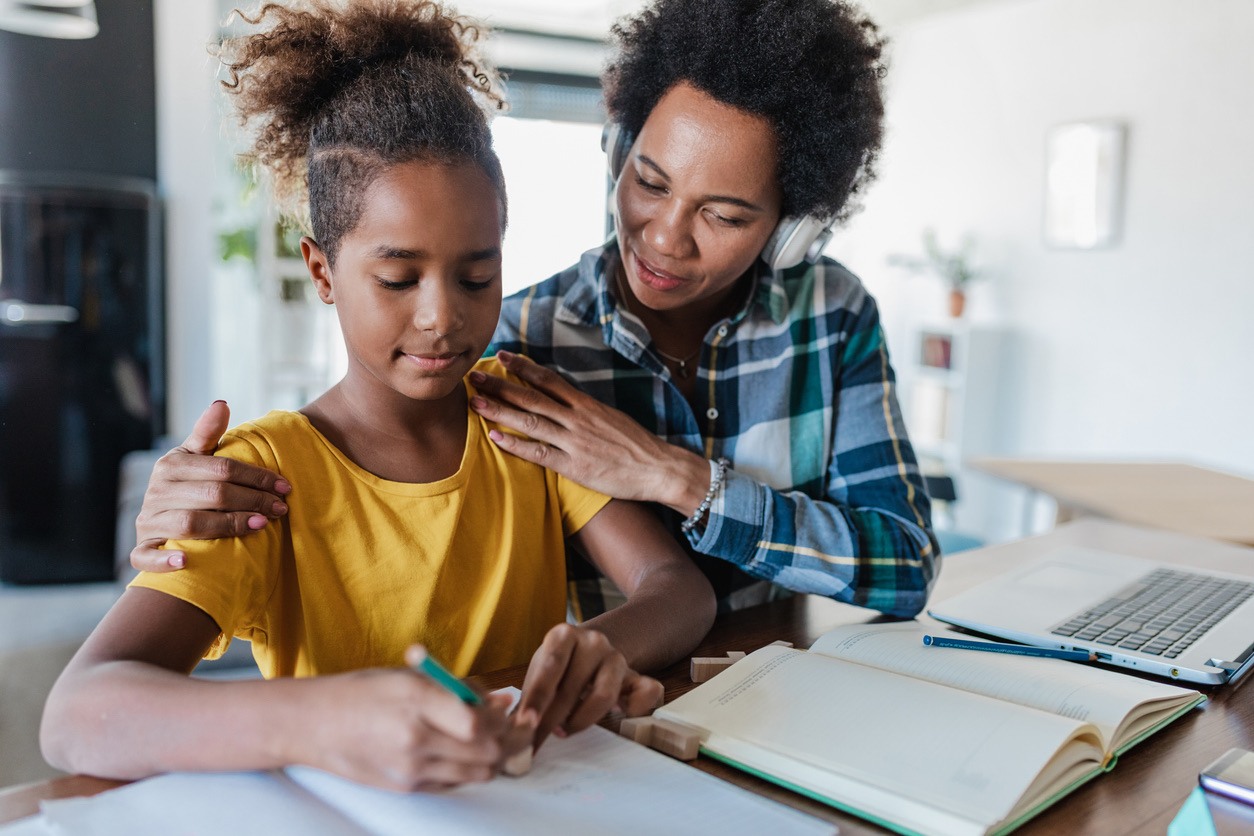 Mother encouraging her daughter during a study session at home.