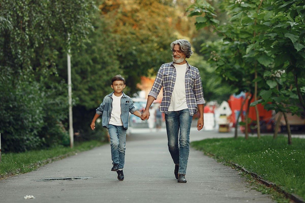 Father and son walking outdoors, fostering critical thinking