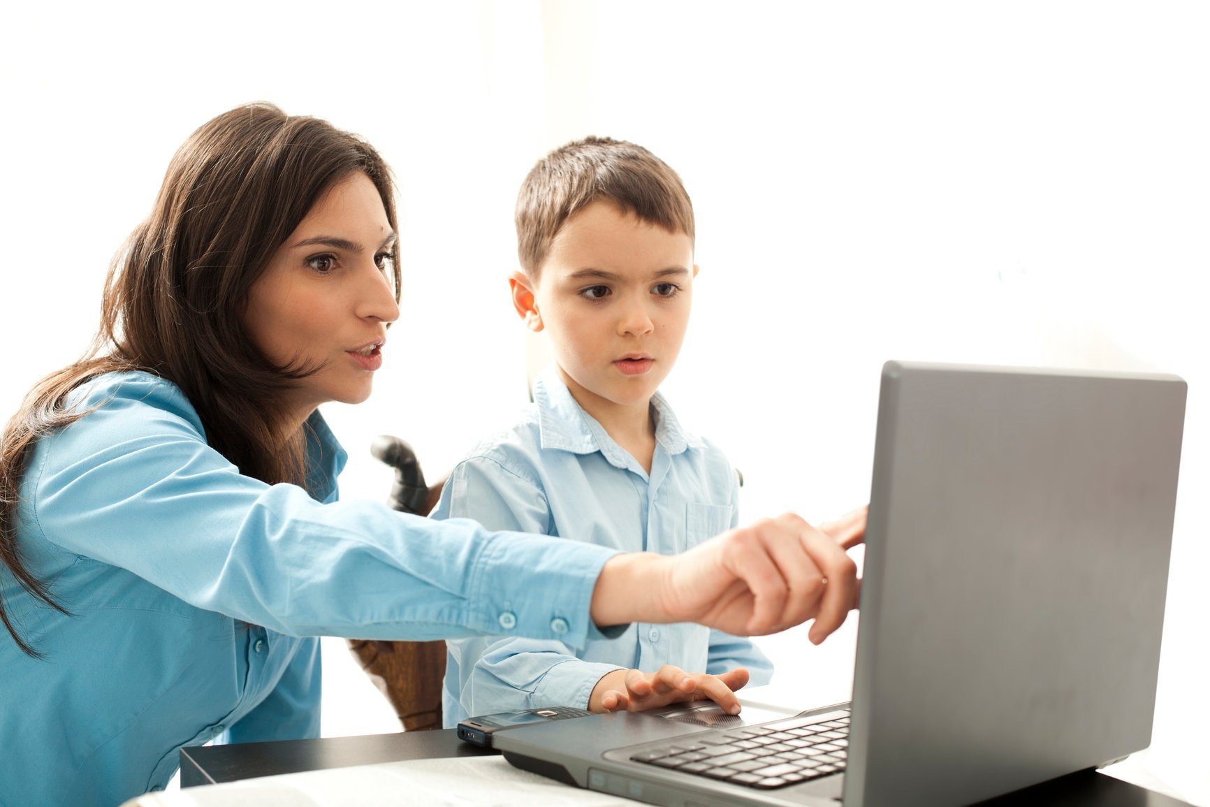 Parent guiding child on how to use a computer with ChatGPT